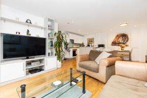 a living room with a large flat screen tv at Immaculate 2BR Flat, Greenwich, 2 min Maze Hill St in London