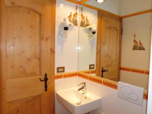 W łazience znajduje się umywalka i lustro. w obiekcie OLIMPIA LODGE w mieście Cortina dʼAmpezzo