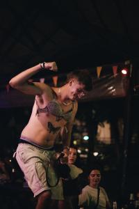 a shirtless man standing in front of a crowd at Blanco Hostel Lanta 18 to 35 in Ko Lanta +24 photos