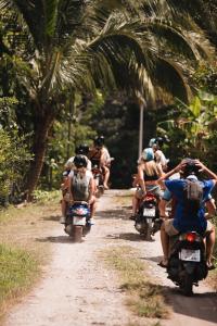 a group of people riding motorcycles down a dirt road at Blanco Hostel Lanta 18 to 35 in Ko Lanta