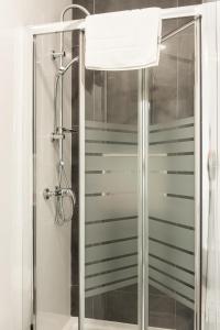 a shower with a glass door in a bathroom at Acanthus in Seville