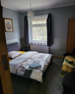 Schlafzimmer mit einem Bett und einem Fenster in der Unterkunft Gościniec Złoty Krąg in Kobylnica