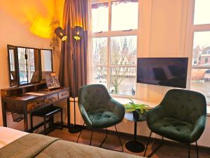 een woonkamer met 2 stoelen en een televisie bij Hotel Anna Casparii in Harlingen