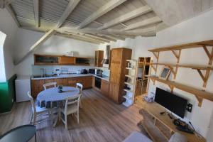 a kitchen and dining room with a table and a television at Nid douillet 2ou4 p à St Pierre de Chartreuse in Saint-Pierre-de-Chartreuse