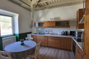 uma cozinha com uma mesa e uma bancada em Nid douillet 2ou4 p à St Pierre de Chartreuse em Saint-Pierre-de-Chartreuse