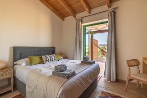 Schlafzimmer mit einem Bett und einer Glasschiebetür in der Unterkunft Monte Flora Farmhouse in Sardoa