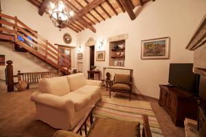 a living room with a couch and a tv at Casale Alessandri in Massa Martana