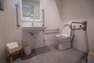 a bathroom with a sink and a toilet and a mirror at Gest in Mellieħa