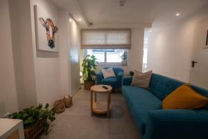 a living room with a blue couch and two chairs at Gest in Mellieħa