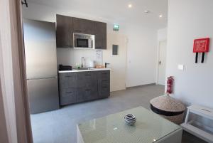 a kitchen with a stainless steel refrigerator and a table at Gest in Mellieħa