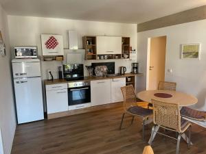 a kitchen with a table and a table and chairs at Wohnung Utkiek - Alte Schule in Glowe