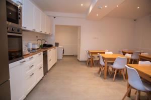a kitchen with white cabinets and a table and chairs at Gest in Mellieħa