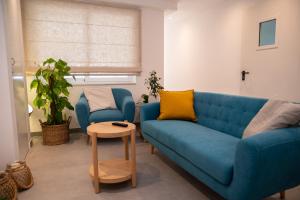 a living room with a blue couch and a table at Gest in Mellieħa