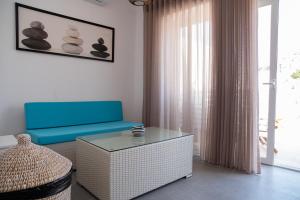 a living room with a blue couch and a table at Gest in Mellieħa