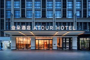 Atour Hotel Meizhou West Station R&F Center في ماوزو: منظر خارجي لفندق المطار مع وضع لافته عليه
