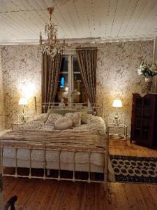 Un dormitorio con una cama grande y una lámpara de araña. en Wedbergs Rum, en Säffle