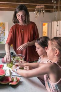 a woman and two girls preparing food in a kitchen at Seek and Hide - Little Emma's Hideaway in Braşov