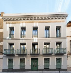 un edificio de apartamentos con puertas verdes y balcones en Acanthus, en Sevilla