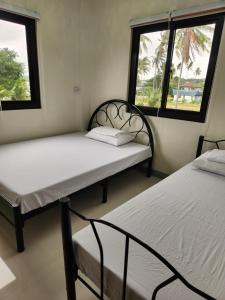 Ένα ή περισσότερα κρεβάτια σε δωμάτιο στο Triple J Villa Puerto Galera