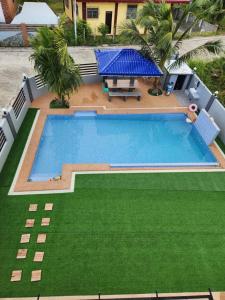 uma vista sobre uma piscina com relva verde em Triple J Villa Puerto Galera em Puerto Galera