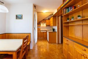 een keuken met houten kasten en een tafel en stoelen bij Apartment Alpinea in Bohinj
