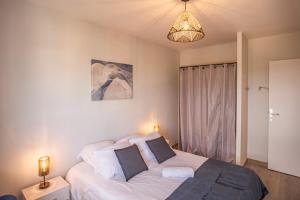 een slaapkamer met een bed met witte lakens en kussens bij Horizon de Troyes - 3 chambres TV - Parking Privé in Troyes