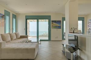 a living room with a couch and a table at Ouzo Panoramic Houses 2, with private pool in Plomarion