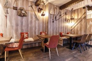 Apartaments La Neu في أوردينو: مطعم بجدران خشبية وطاولات وكراسي خشبية