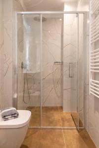 La salle de bains est pourvue d'une douche en verre et de toilettes. dans l'établissement Nicolas Centrale-Smart City Suites, à Igoumenítsa
