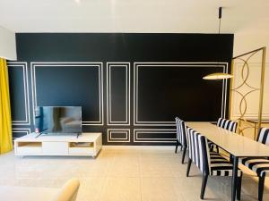 a dining room with a black wall and a table and chairs at AXON APARTMENT RESIDENTIAL SUITE in Kuala Lumpur