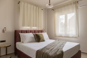 una camera da letto con un grande letto e una finestra di Chelmis Sea Front Apartments - Atlantis ad Argostoli