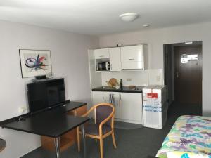 a small room with a desk and a table and a kitchen at Business apartment in 3 star hotel Daimler Nah in Sindelfingen