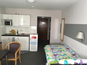 a small room with a bed and a kitchen at Business apartment in 3 star hotel Daimler Nah in Sindelfingen