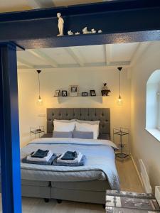 - une chambre avec un grand lit aux murs bleus dans l'établissement Bed & Breakfast Mir Lo, à Mierlo