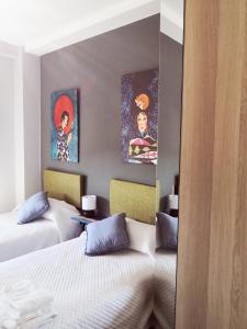1 dormitorio con 2 camas y pinturas en la pared en Vista triangular, en Las Palmas de Gran Canaria