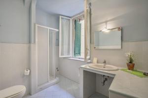 een badkamer met een wastafel, een toilet en een raam bij Rooms Corte Delle Uova Centro Storico Piazza San Michele in Lucca