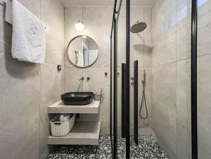 a bathroom with a sink and a glass shower at Chelmis Sea Front Apartments - Atlantis in Argostoli