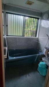 a bathroom with a bath tub and a window at Whole house rental inn Horizon line - Vacation STAY 18087v in Yakushima