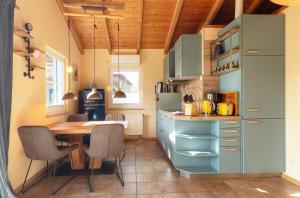 a kitchen with a wooden table and a blue refrigerator at Blau am See in Jabel