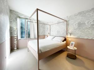 um quarto com uma cama de dossel e uma janela em CozyClouds vicino Piazza del Campo em Siena