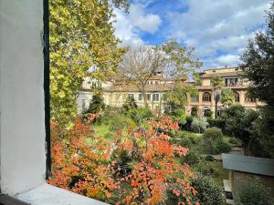 uma vista para um jardim com um edifício ao fundo em CozyClouds vicino Piazza del Campo em Siena