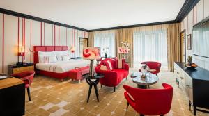 a hotel room with a bed and red chairs at Dinamo Hotel Baku in Baku
