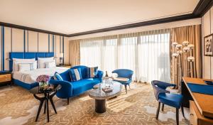 a hotel room with a bed and blue chairs at Dinamo Hotel Baku in Baku
