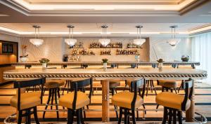 a restaurant with a large bar with stools at Dinamo Hotel Baku in Baku