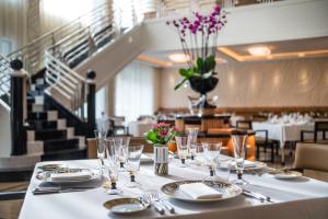a table with plates and glasses on a table in a restaurant at Dinamo Hotel Baku in Baku