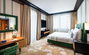 a hotel room with a bed and a desk and a television at Dinamo Hotel Baku in Baku