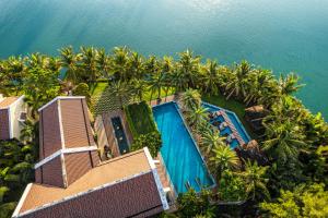 - une vue aérienne sur un complexe avec une piscine et des palmiers dans l'établissement Koi Resort & Spa Hoi An, à Hội An