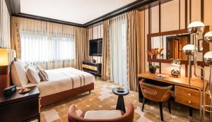 a hotel room with a bed and a desk and a computer at Dinamo Hotel Baku in Baku