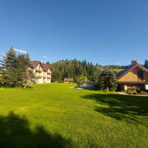 een groot grasveld met een huis en bomen bij Tylicki Zdrój in Tylicz