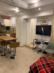 a living room with a table and a flat screen tv at 19 Atelier Montorgueil in Paris